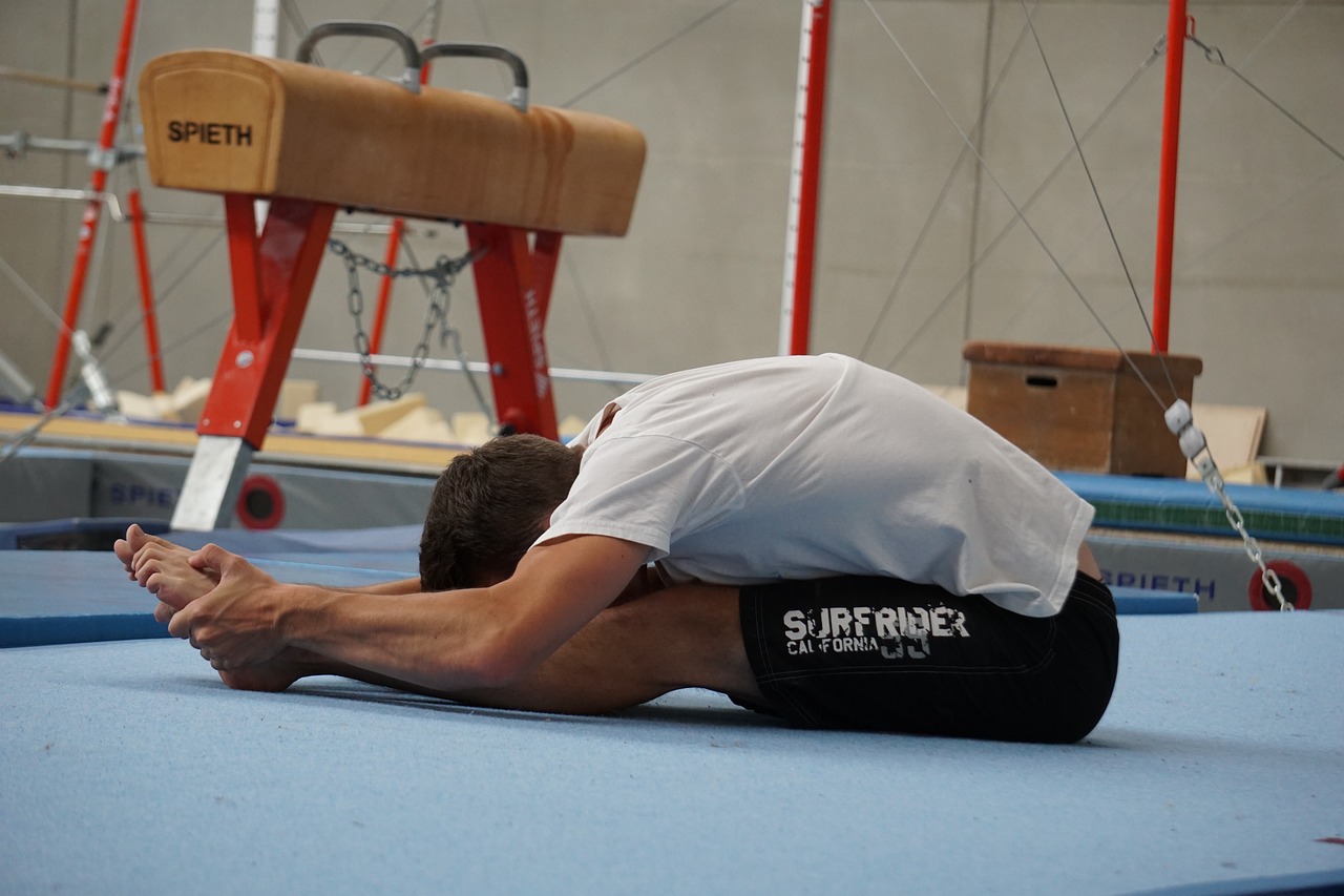 Man stretching forward reaching towards his toes.