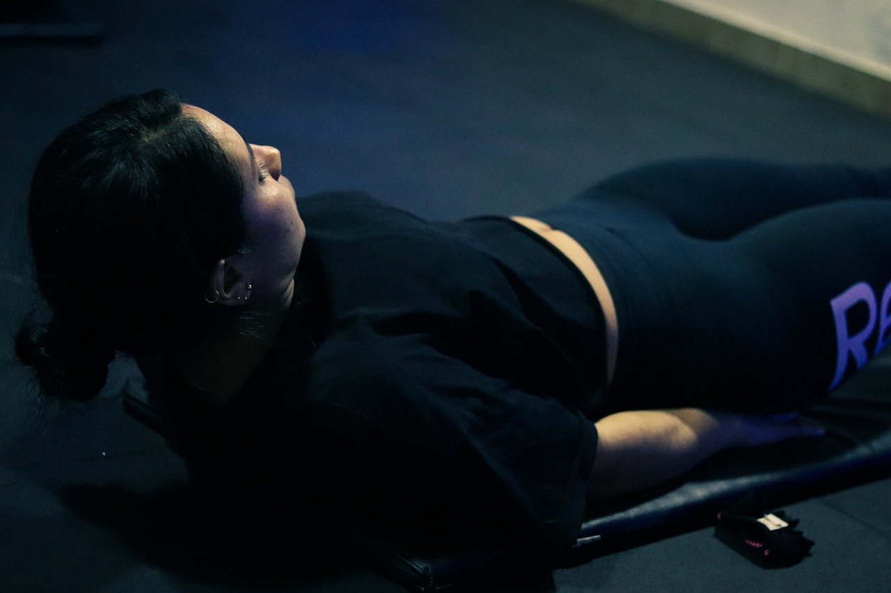 Woman lying on her back doing bench presses.