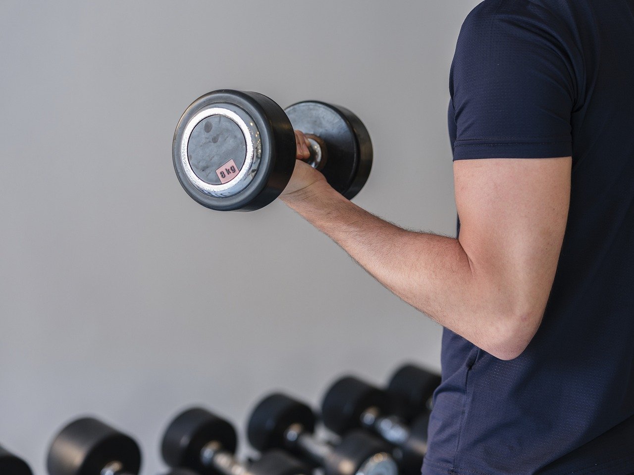 Close-up of a man's arm lifting a dumbbell.